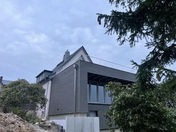 Feuerverzinktes Füllstabgeländer auf der Dachterrasse eines Anbaus mit Holzfassade