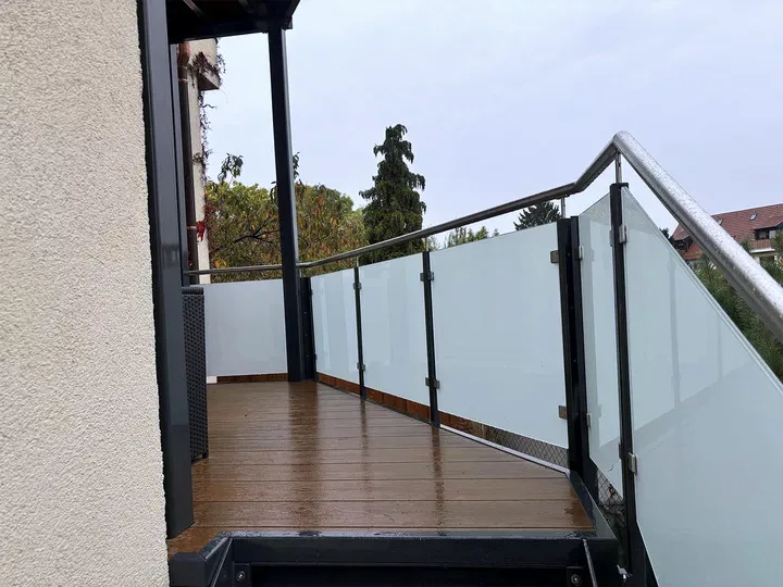 Balkon mit mattem Glasgeländer, Edelstahl-Handlauf und WPC-Boden