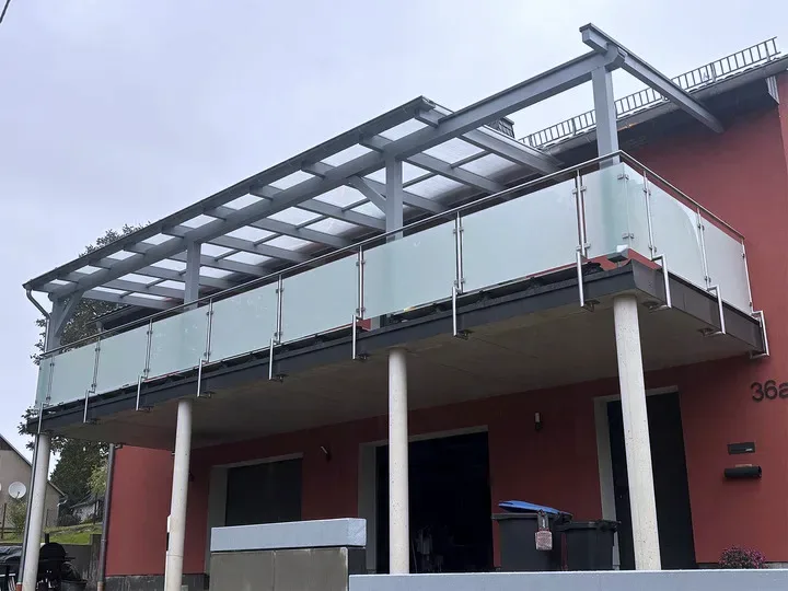 Edelstahlgeländer mit mattem Glas an einem überdachten Balkon