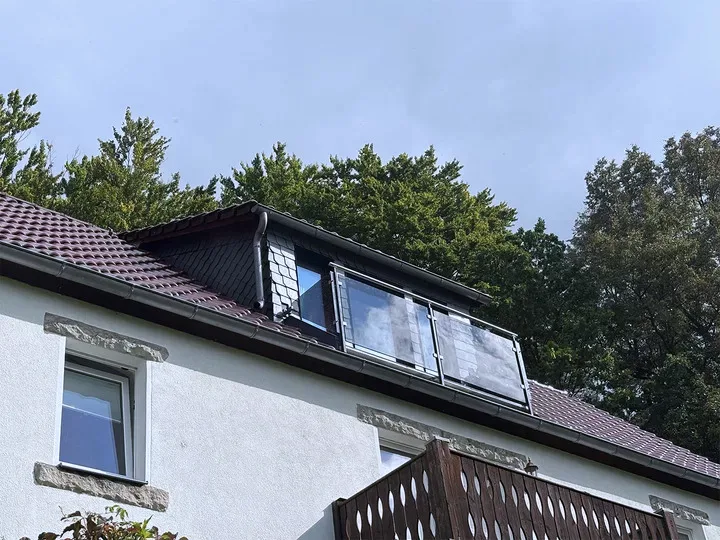Glasgeländer mit Edelstahl-Handlauf am Balkon einer Dachgaube