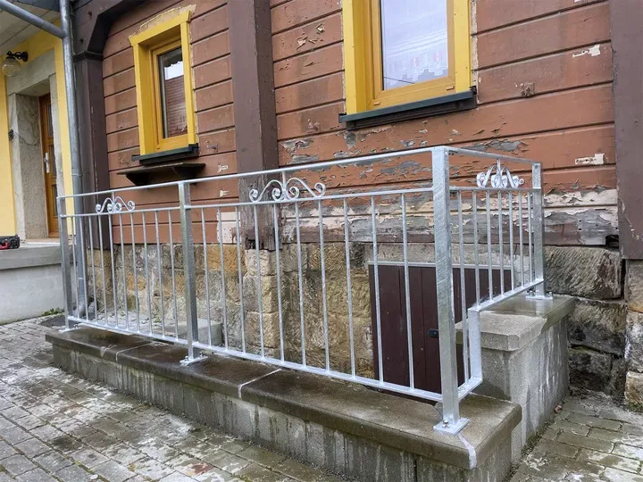 Feuerverzinktes Brüstungsgeländer mit Zierelement am Kellereingang