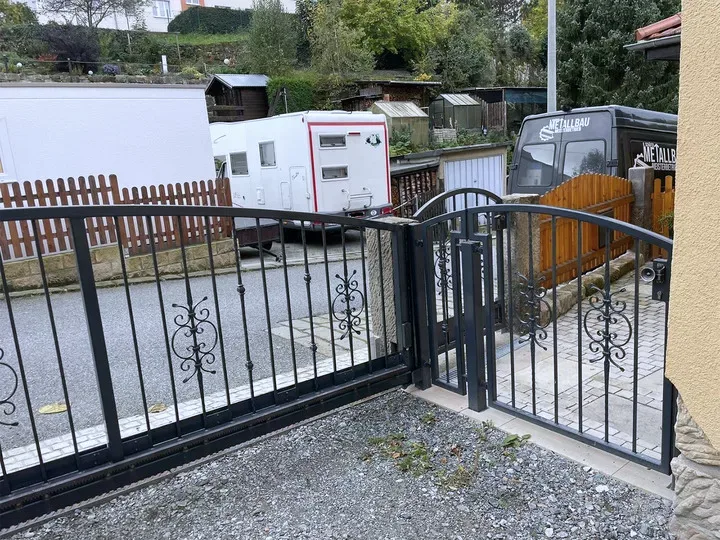 Anthrazitfarbene Toranlage mit Schiebetor und Gehtür
