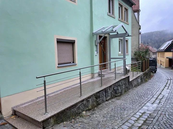 Edelstahlgeländer entlang einer Rampe zum Hauseingang