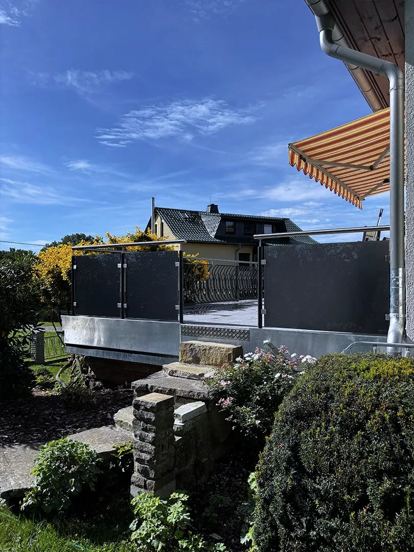 Terrasse von außen mit Glasfeldern und Edelstahl-Handlauf