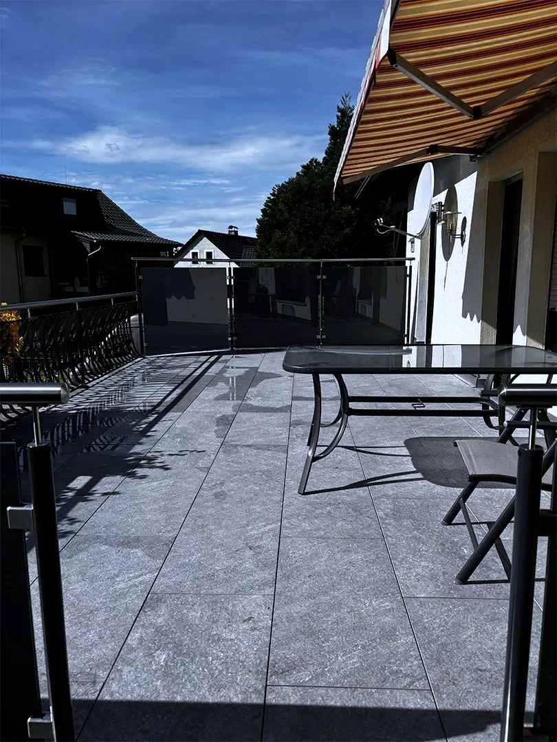 Terrassengeländer entlang der Hausseite mit Glasfeldern und Edelstahl-Handlauf