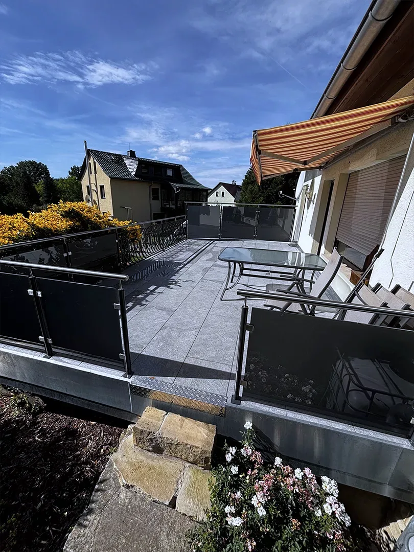 Terrassengeländer mit grauem Mattglas und aufgearbeiteten Zierfeldern