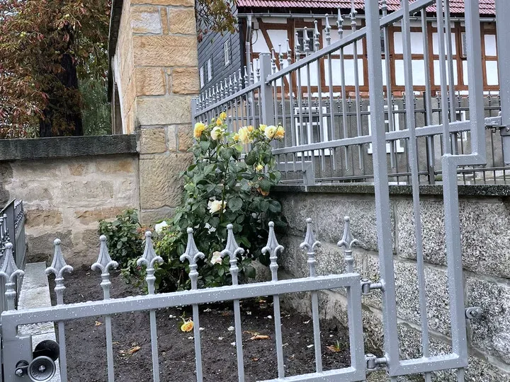 Zaun mit Spitzen auf einer Natursteinmauer, feuerverzinkt und pulverbeschichtet